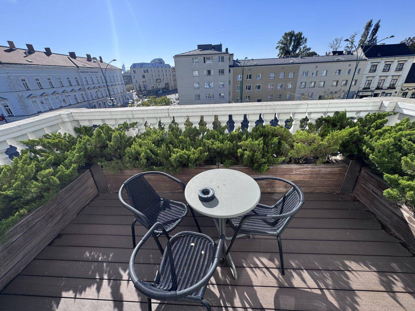 Eine gemütliche Dachterrasse mit Holzboden und Pflanzen, perfekt für entspannte Stunden im Freien.