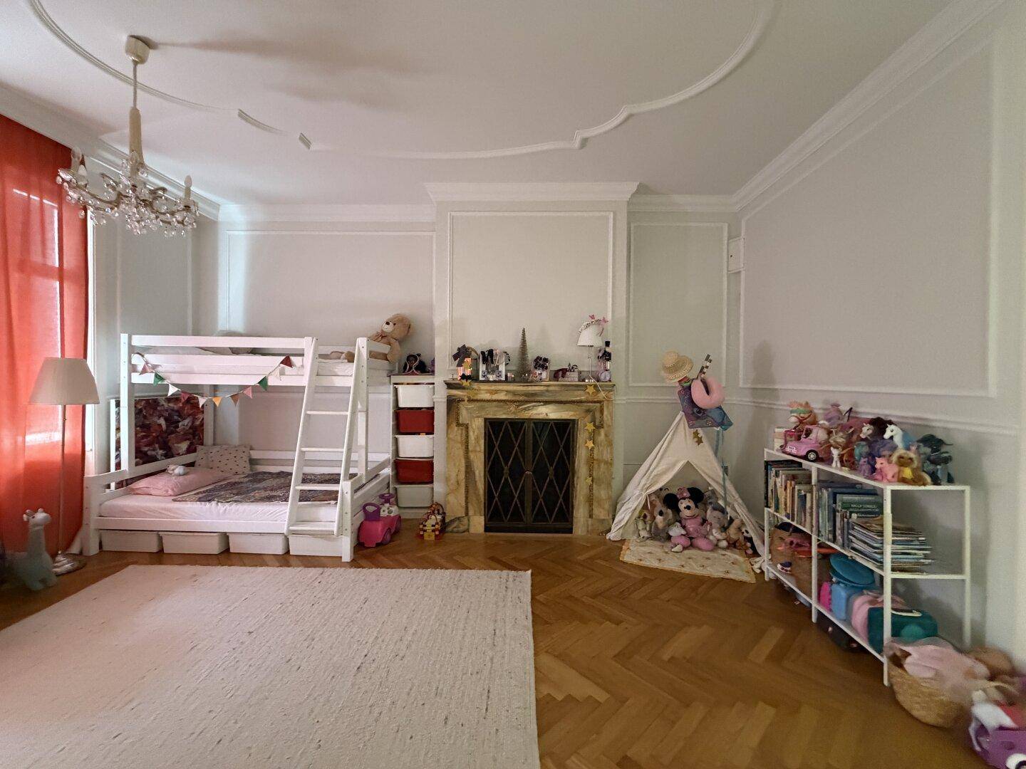 Helles Kinderzimmer mit Etagenbett, Spielzeug und Parkettboden.