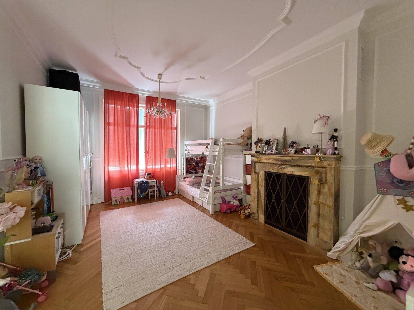 Geräumiges Kinderzimmer mit Etagenbett, Parkettboden und dekorativem Kamin.