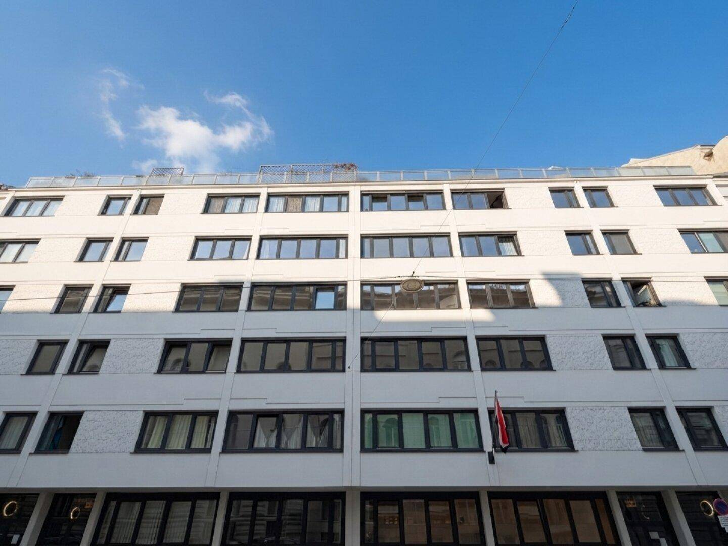 Ansicht der modernen Gebäudefassade mit vielen Fenstern und klarem blauem Himmel.