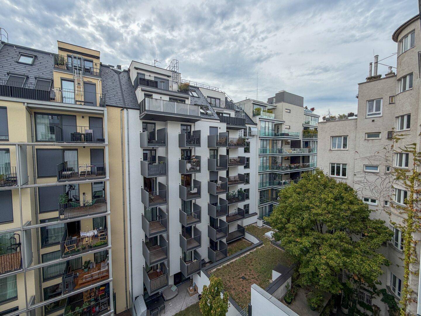 Moderne Wohngebäude mit zahlreichen Balkonen und begrünten Dächern in urbaner Umgebung.