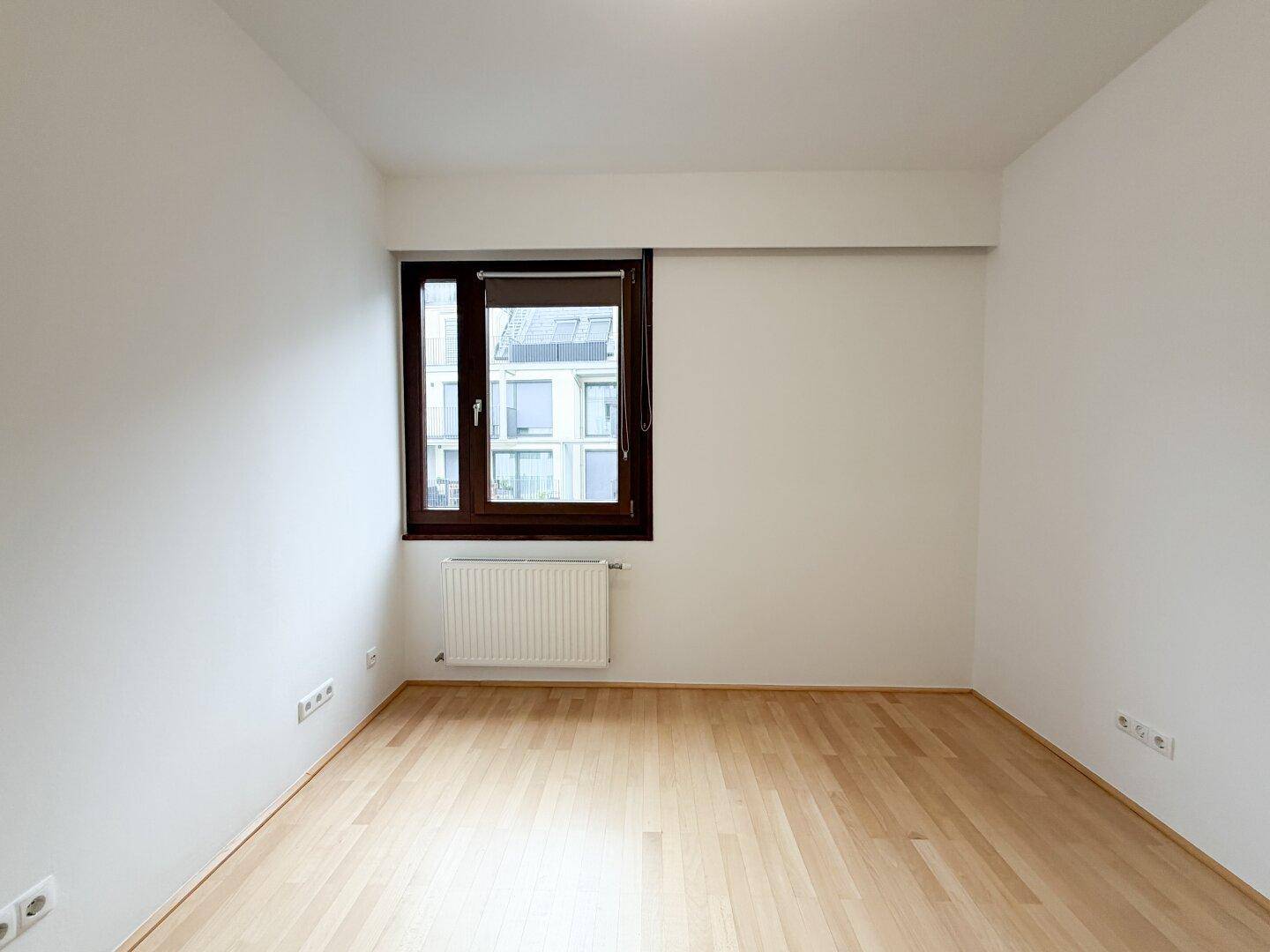 Unmöbliertes Schlafzimmer mit Parkettboden und Fenster, ideal für individuelle Gestaltung.