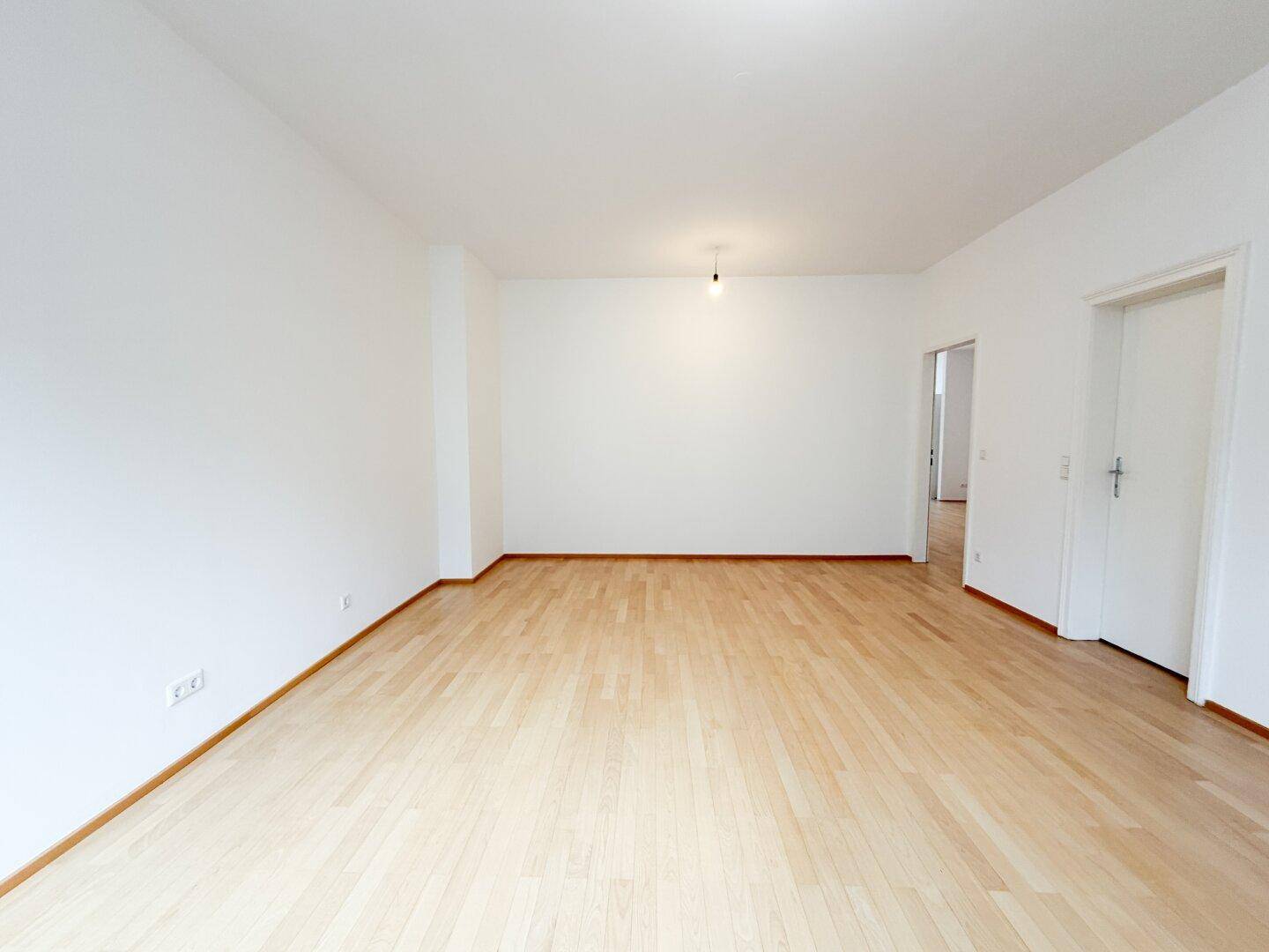 Leeres Schlafzimmer mit Parkettboden und weißen Wänden, bereit zur individuellen Gestaltung.