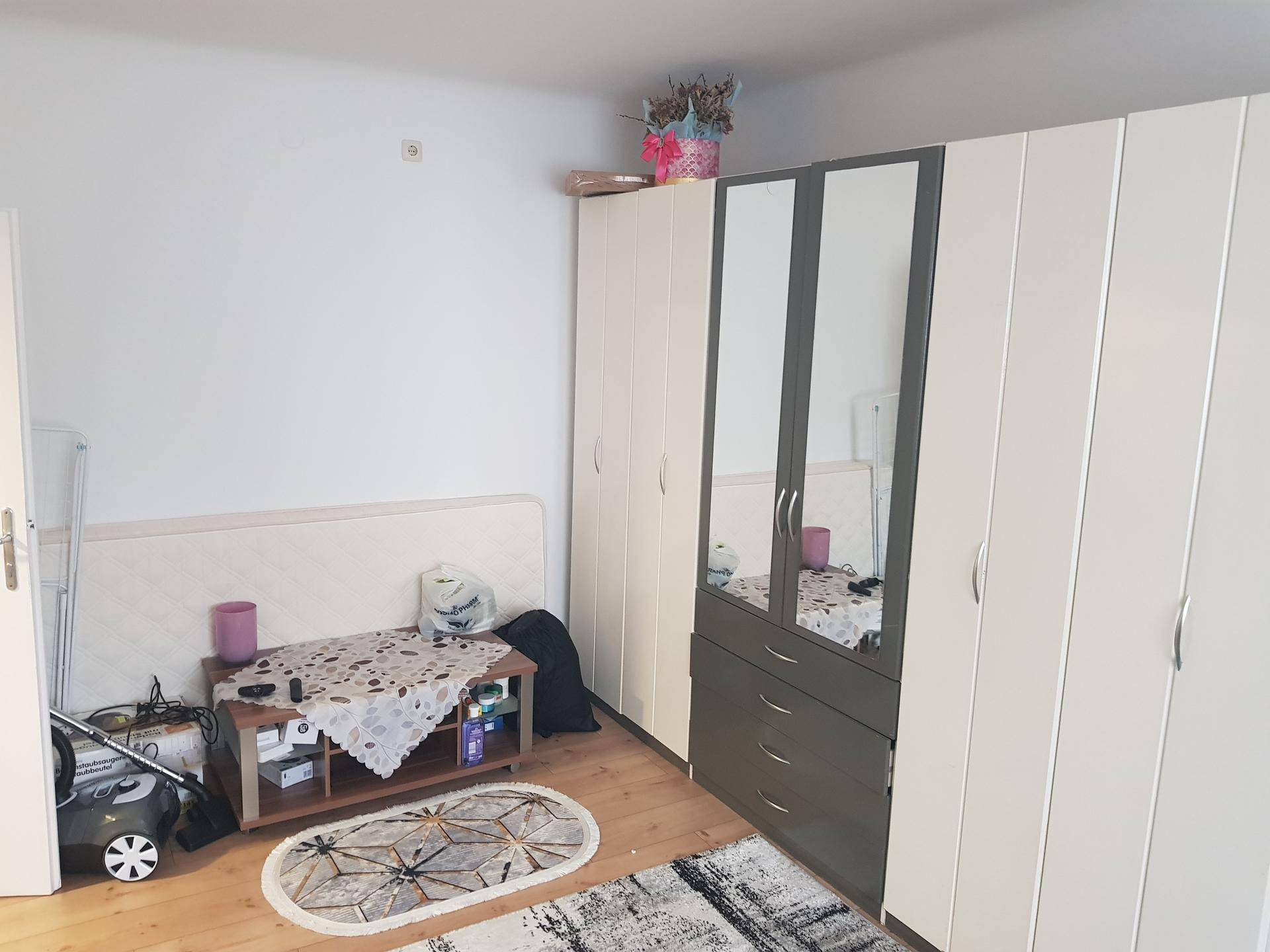 Schlafzimmer mit Bett und großem Kleiderschrank, der viel Stauraum bietet.
