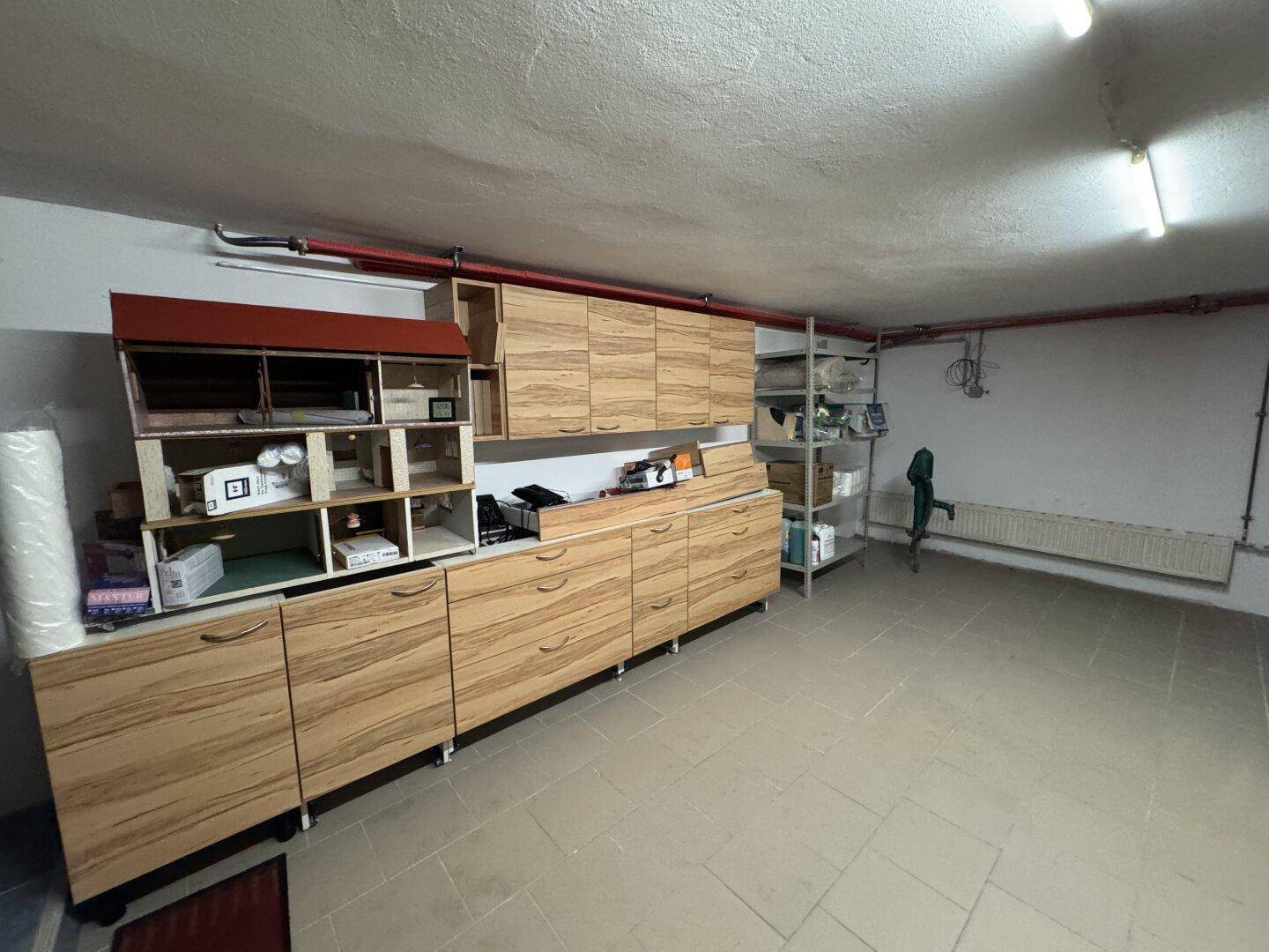 Geräumiger Abstellraum mit vielen Holzschränken und Regalen für Lagerung.