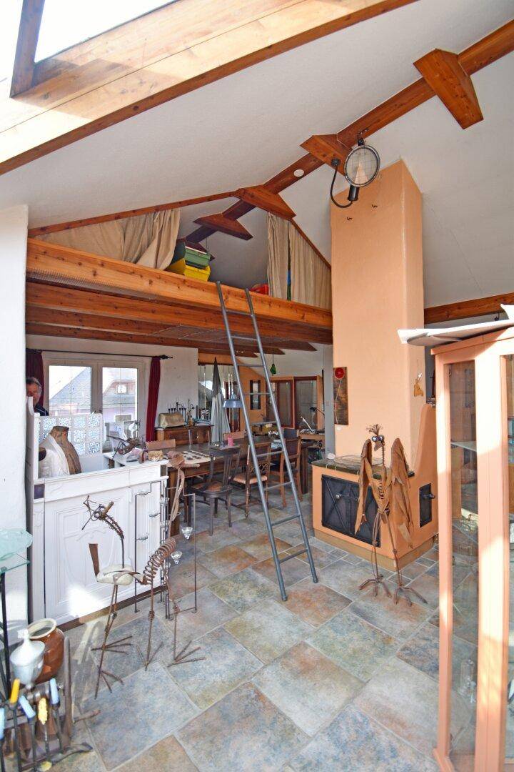 Geräumiger Wohnbereich mit Holzbalken, Galerie und Blick auf den Wintergarten.