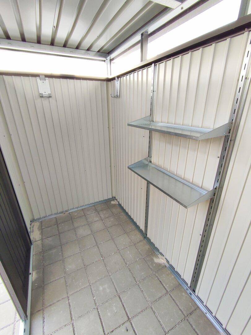 Innenansicht eines Abstellraums mit Regalen und gefliestem Boden, ideal für zusätzlichen Stauraum.