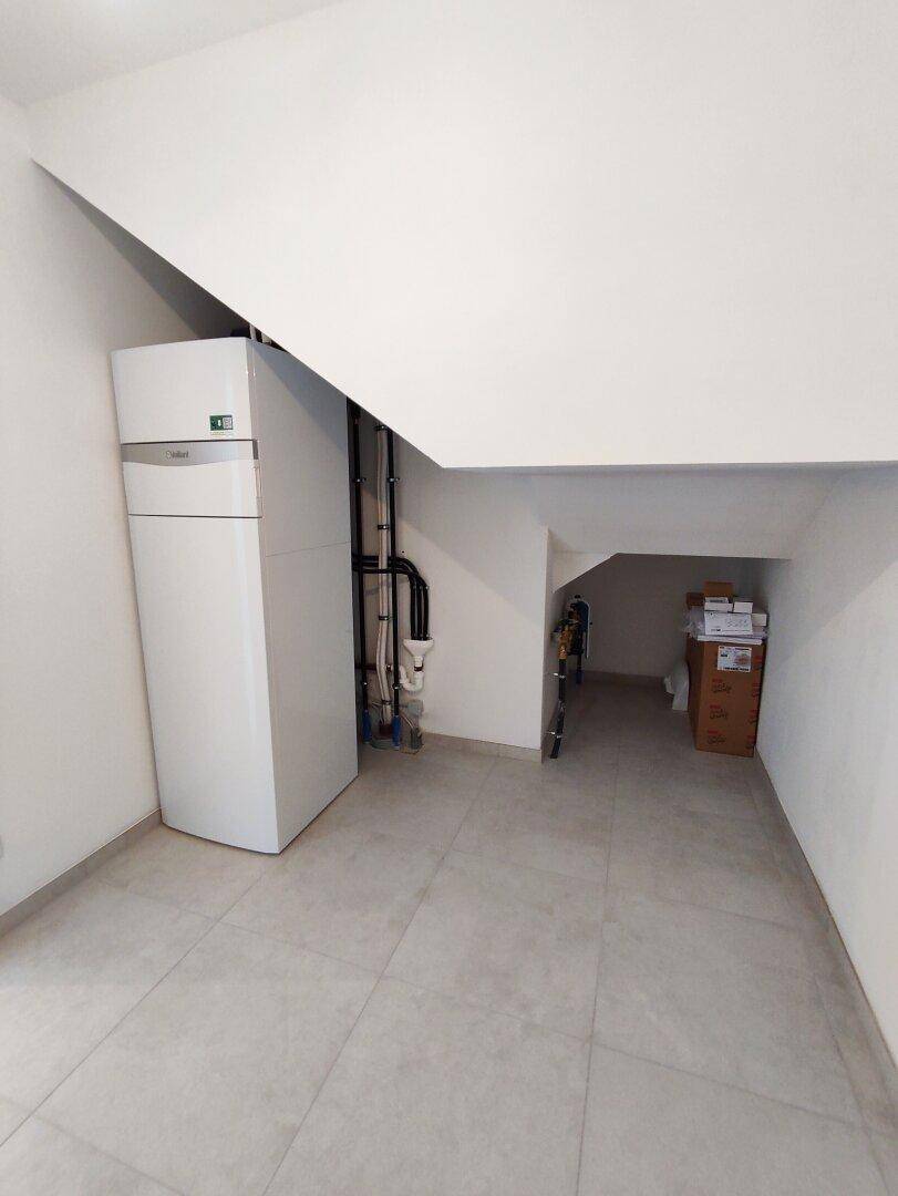 Hauswirtschaftsraum unter der Treppe mit Heizungsanlage und zusätzlichem Stauraum.