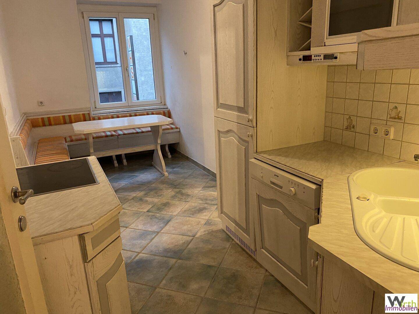 Geräumige Küche mit Essbereich, Fenster und traditionellen Holzschränken.