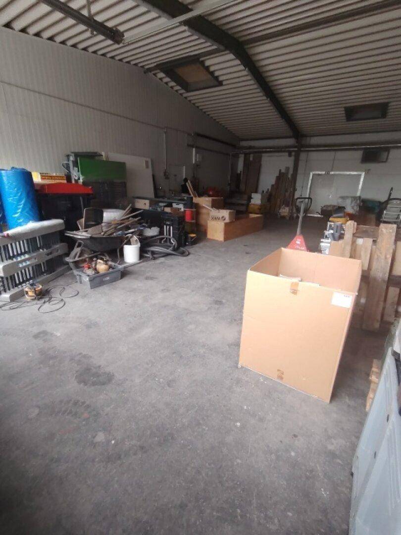 Weitläufige Lagerfläche mit Betonboden und hohen Decken, genutzt für diverse Materialien und Geräte.