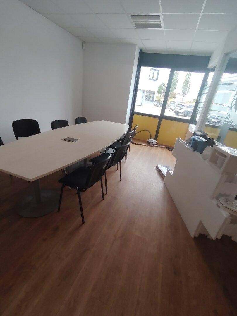 Konferenzraum mit großen Fenstern, die viel Tageslicht hereinlassen, und Blick nach draußen.