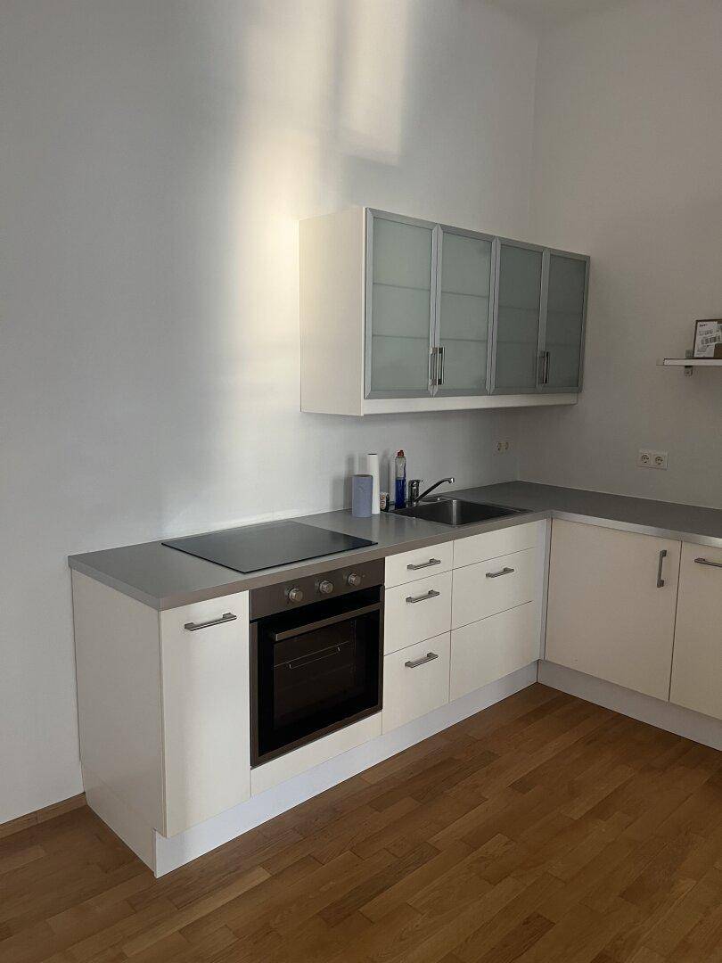 Funktionale Einbauküche mit Kochfeld, Backofen und ausreichend Stauraum, in hellem Design.