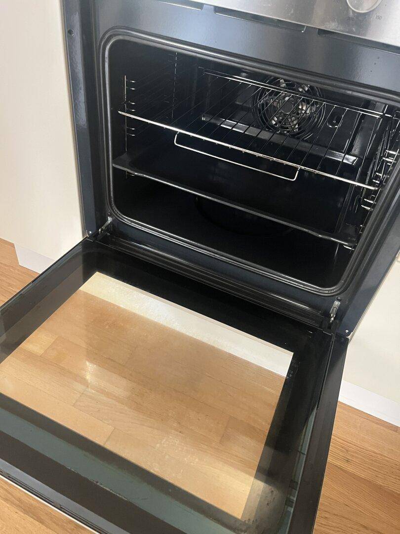 Offener Backofen mit Rost und sauberem Innenraum, bereit für die Zubereitung von Speisen.