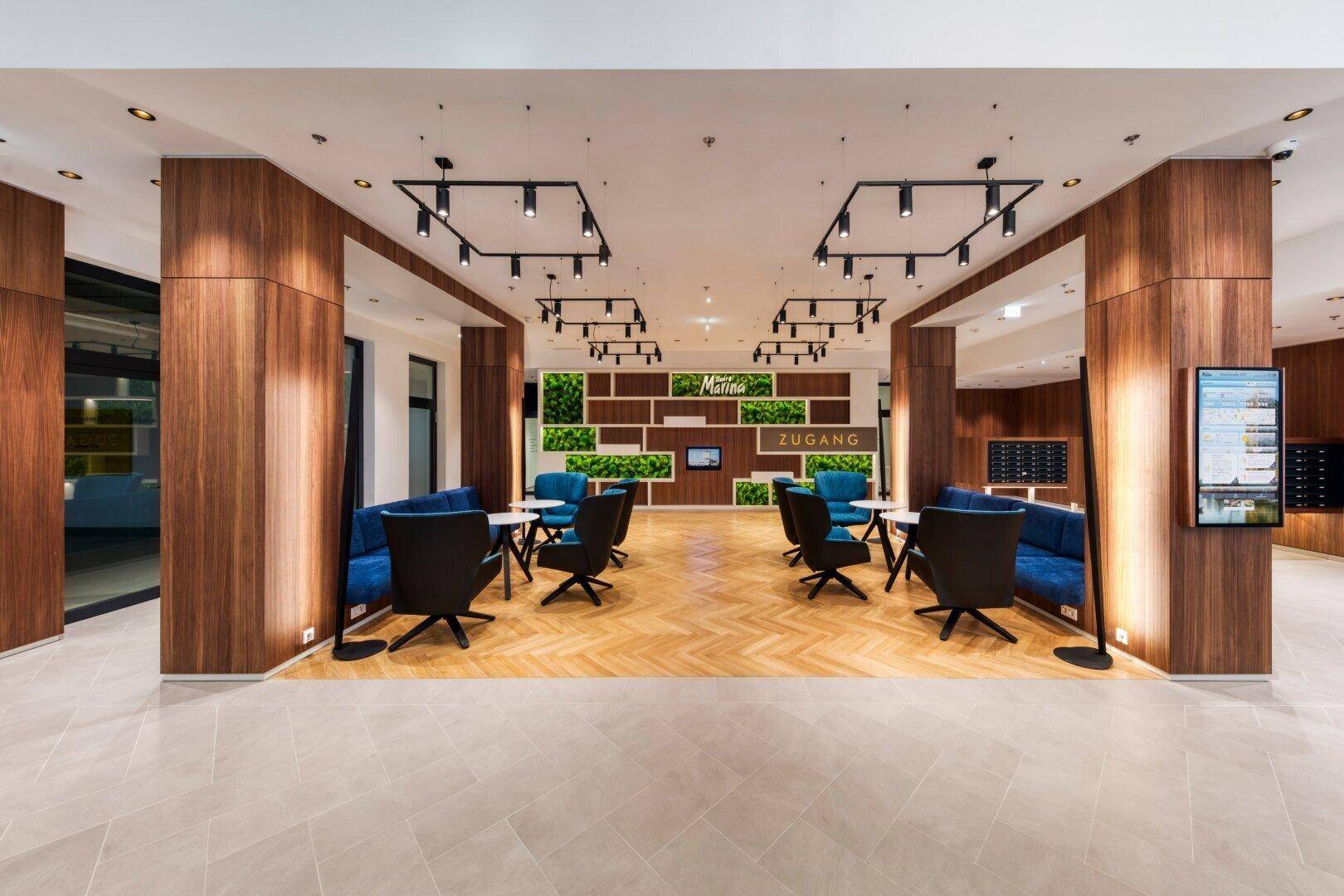 Moderne Lobby mit stilvollen Sitzbereichen, Holzakzenten und dekorativen Mooswänden.
