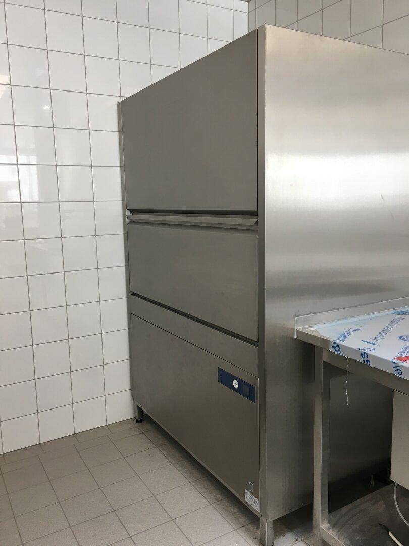 Großer, professioneller Kühlschrank oder Gefrierschrank aus Edelstahl in einer gefliesten Gewerbeküche.