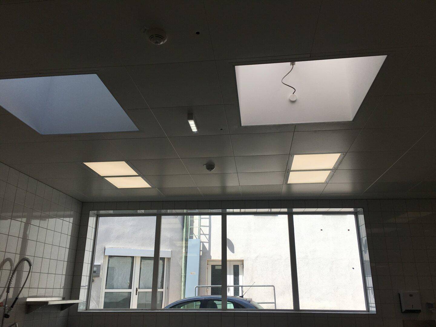 Großes Fenster in einer Gewerbeküche mit Blick nach draußen und Deckenbeleuchtung.