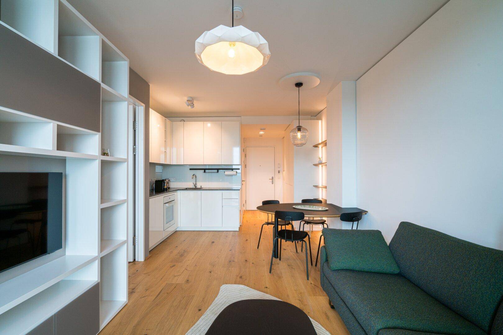 Geräumiger offener Wohnbereich mit integrierter Küche, Essplatz und gemütlichem Sofa.