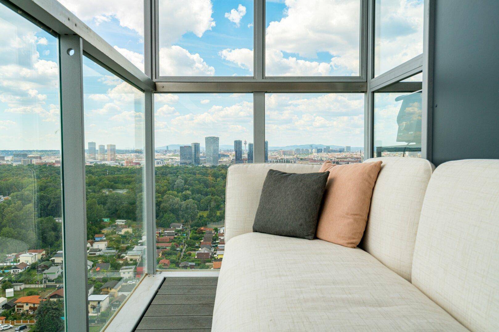 Balkon mit bequemer Liege und beeindruckendem Blick auf die Skyline und die Natur.