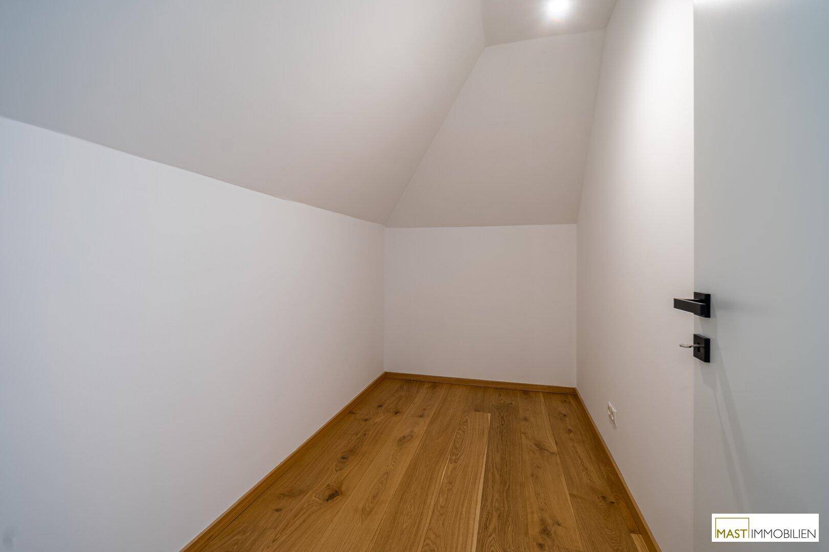 Praktischer Abstellraum mit Holzboden und Dachschräge, ideal für zusätzlichen Stauraum.