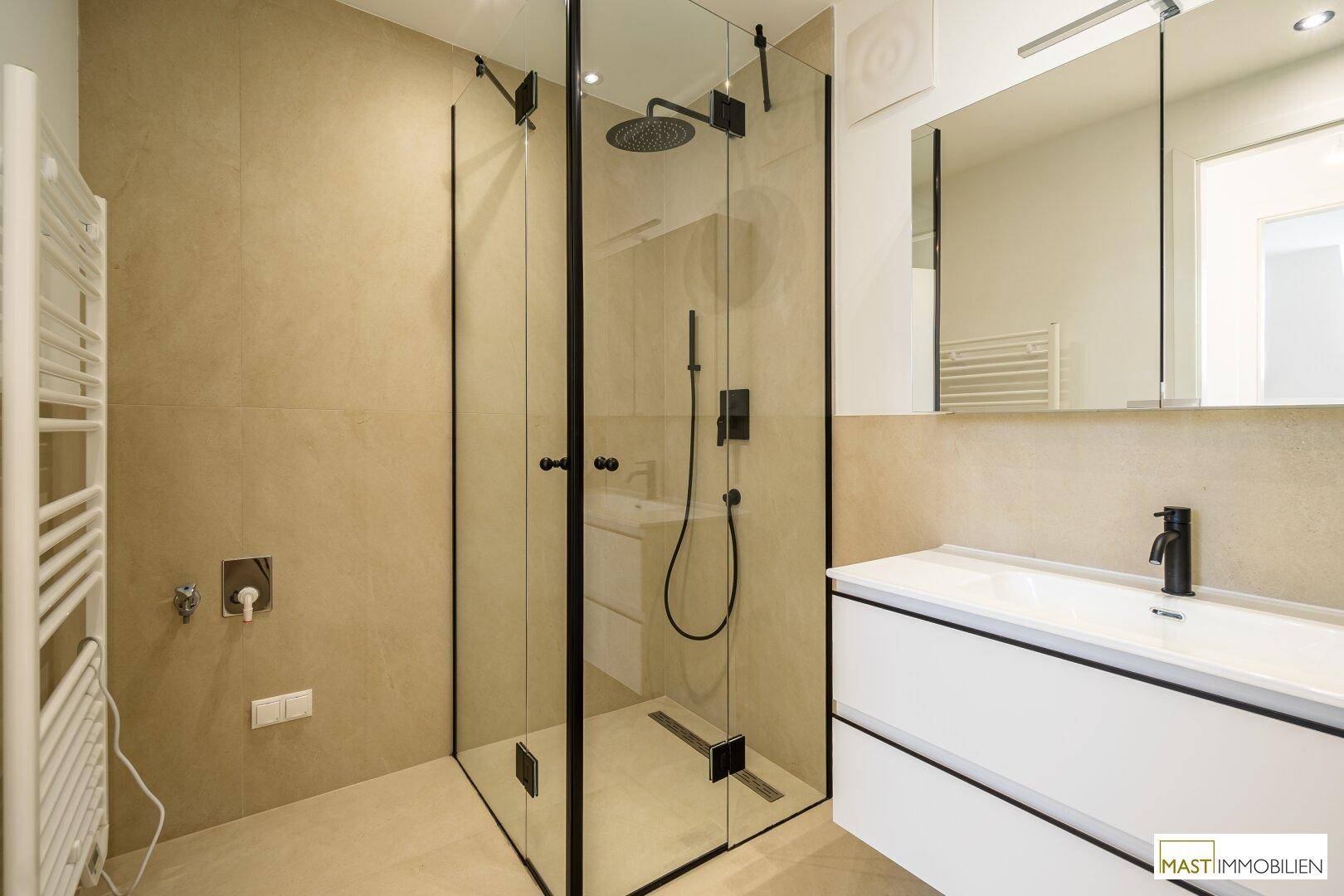 Modernes Badezimmer mit begehbarer Dusche, beigefarbenen Fliesen und schwarzer Armatur.