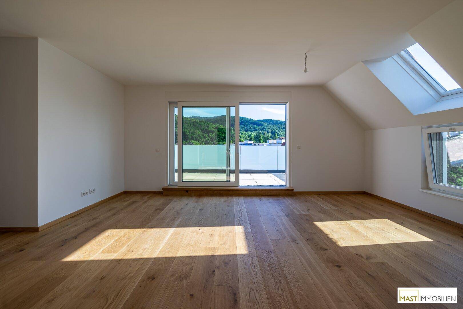 Heller Wohnbereich mit Holzboden, großen Schiebetüren zum Balkon und viel Tageslicht.