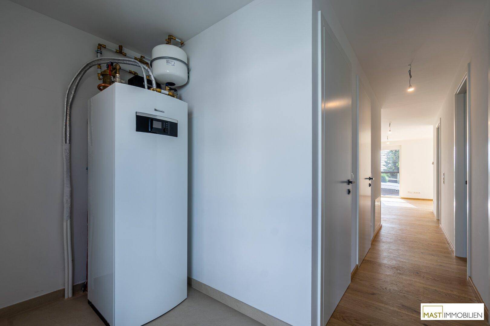Technikraum mit moderner Heizungsanlage und Warmwasserspeicher, sauber und funktional.