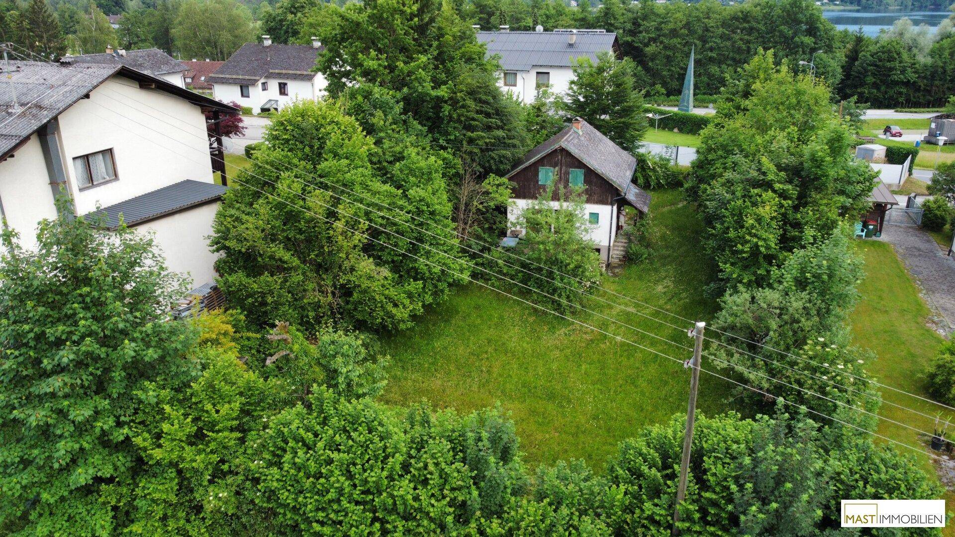 Luftaufnahme des Hauses mit großem Garten, umgeben von Bäumen und weiteren Gebäuden.