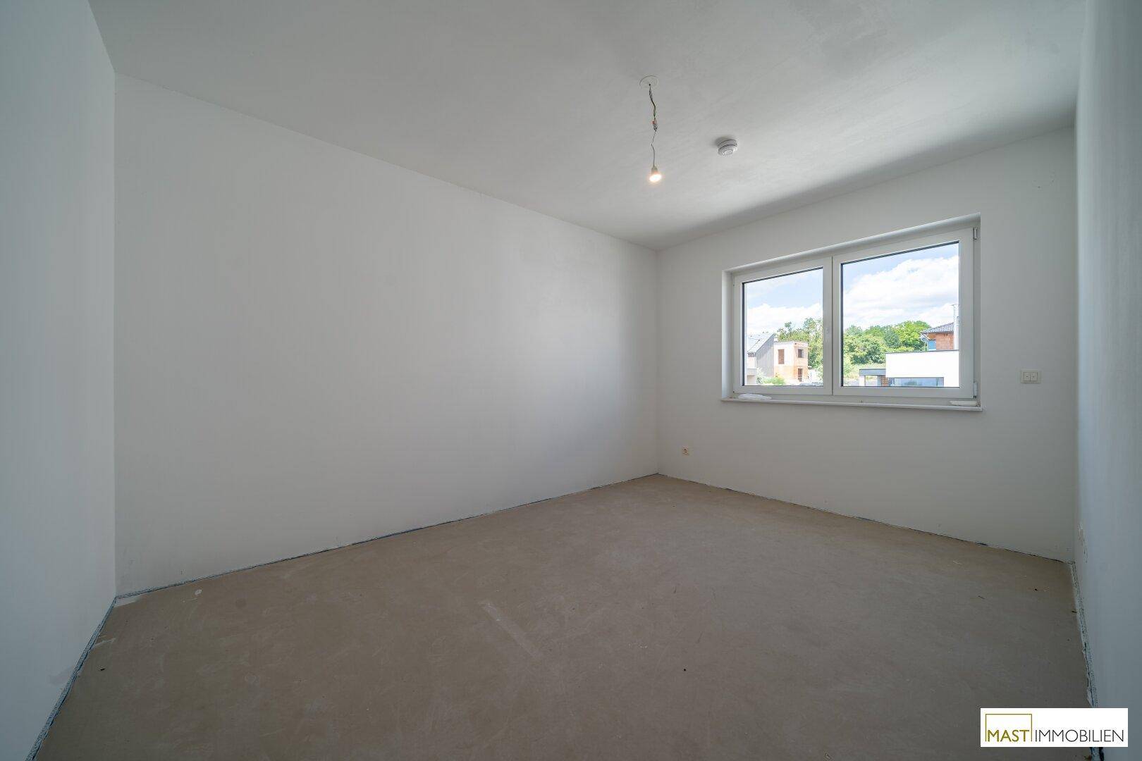 Helles Zimmer mit großem Fenster, das viel Tageslicht hereinlässt und einen weiten Blick bietet.