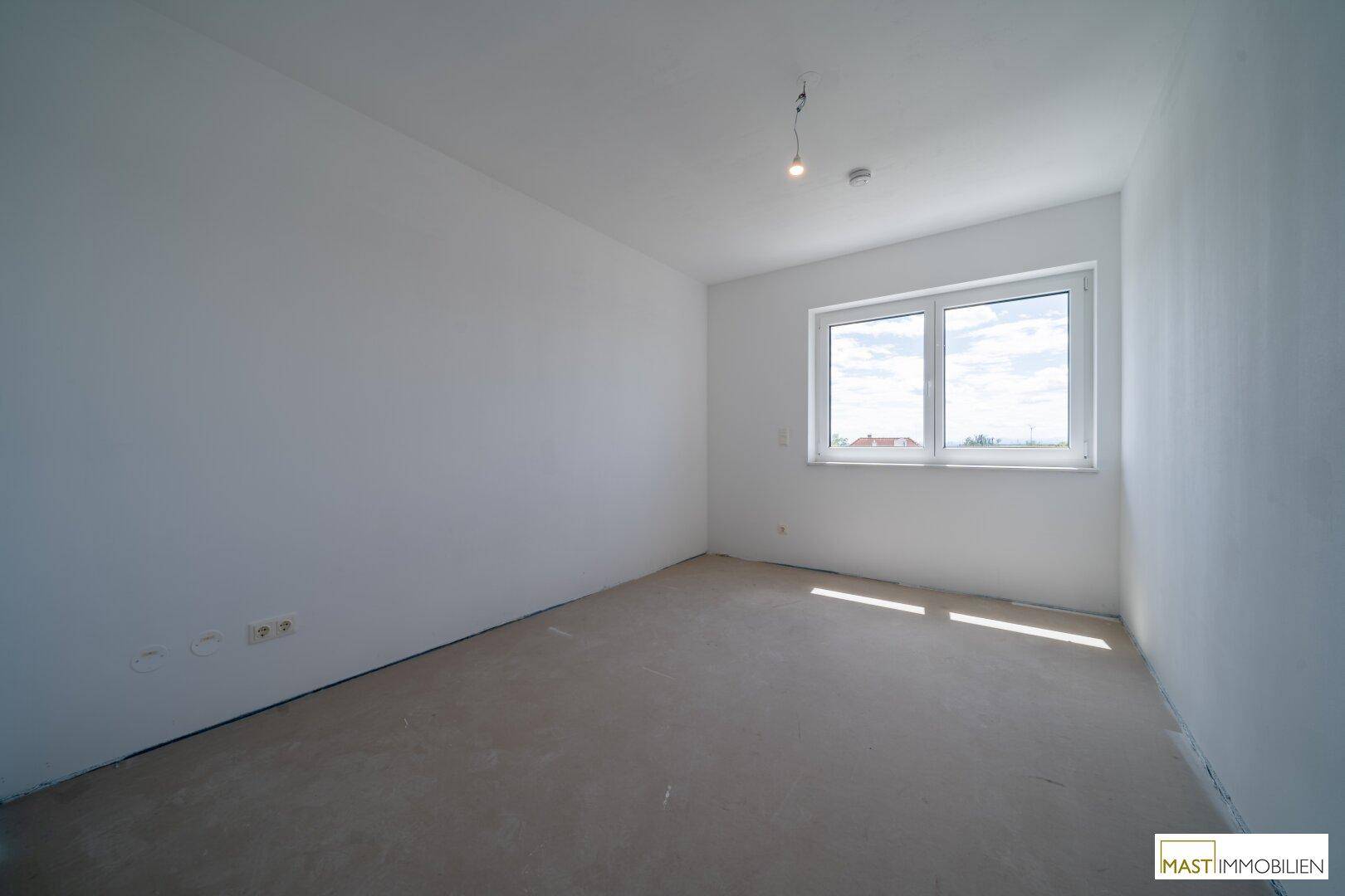 Geräumiges, helles Zimmer im Obergeschoss mit Fenster und Blick auf die Umgebung.