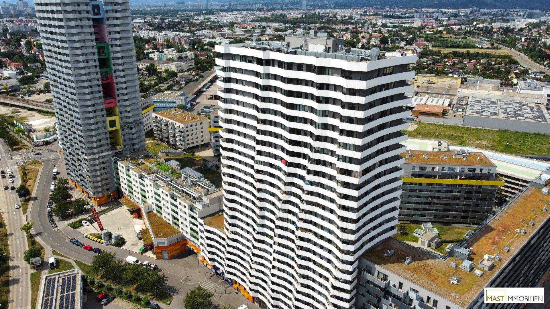Moderne Wohngebäude mit markanter Fassade in Schwarz-Weiß in einer städtischen Umgebung.