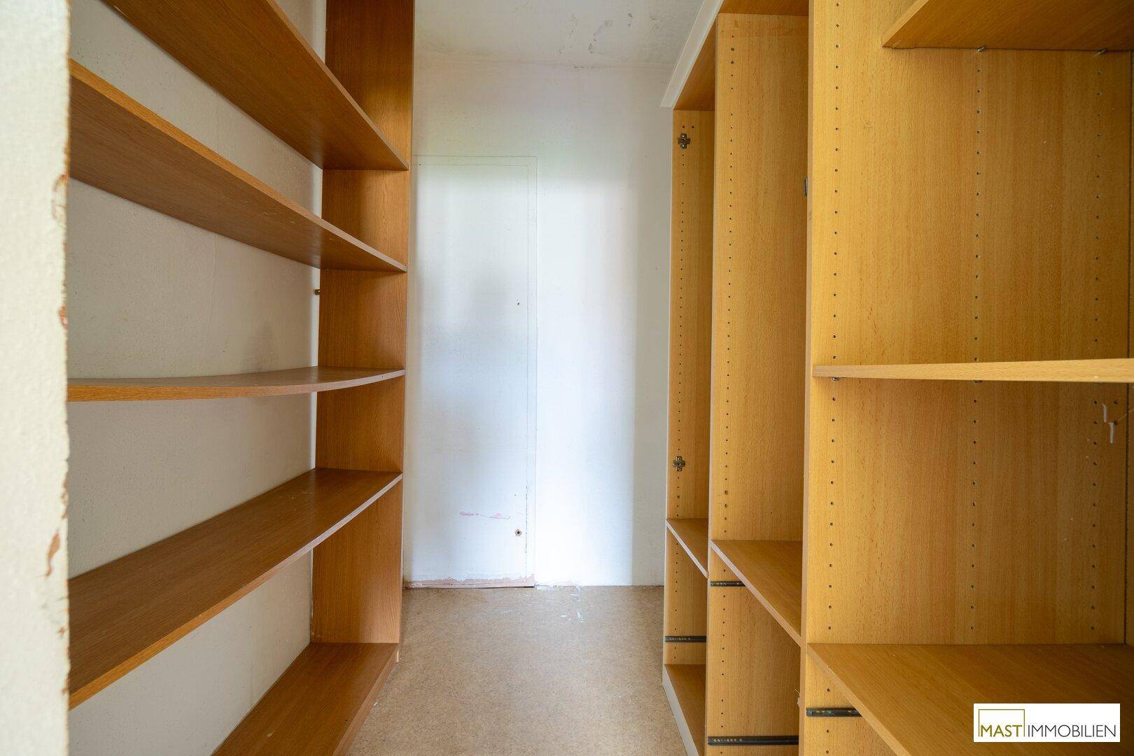 Praktischer Abstellraum mit vielen Holzregalen für zusätzlichen Stauraum und Organisation.