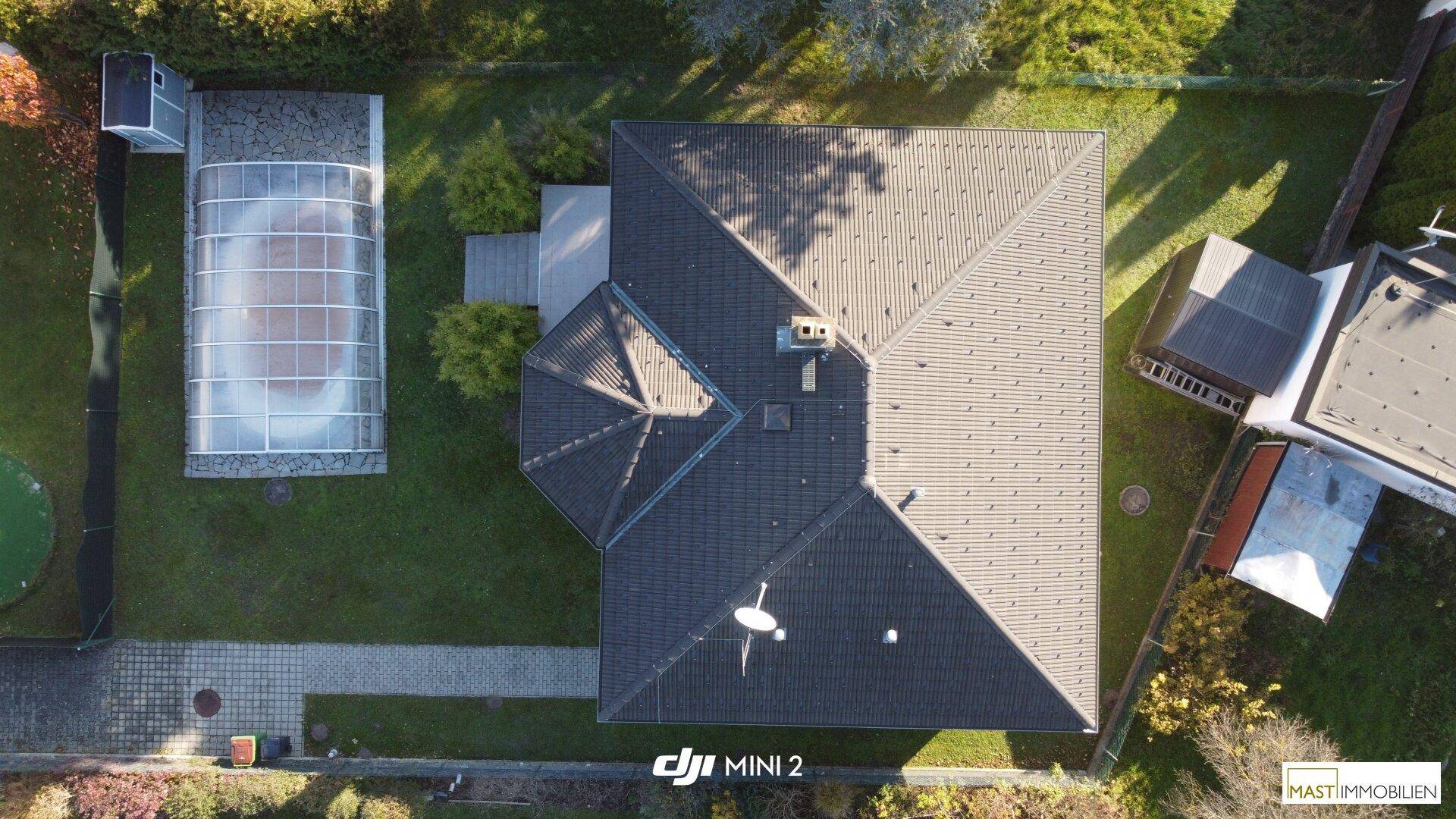 Vogelperspektive des Hauses mit Garten und überdachtem Poolbereich.