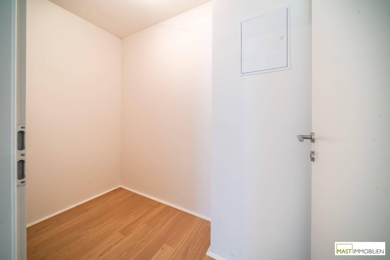 Kleiner, heller Abstellraum mit Holzboden und weißen Wänden, ideal für zusätzlichen Stauraum.