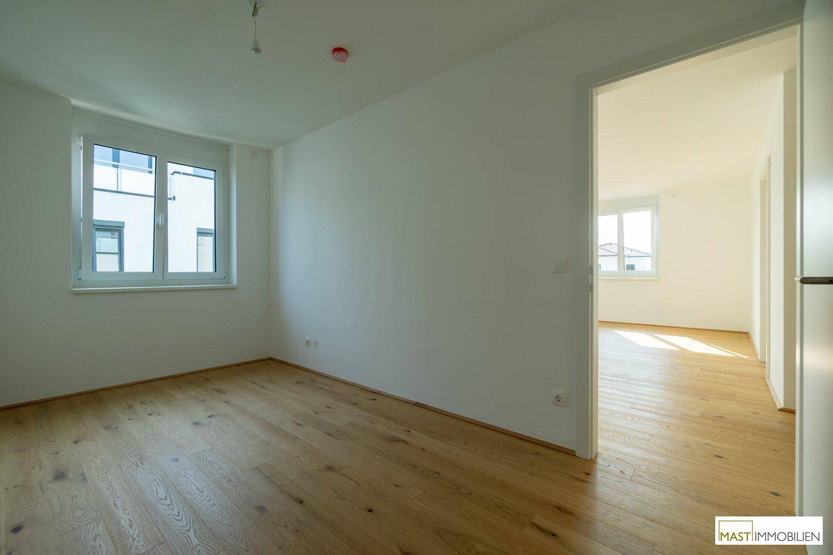Helles Zimmer mit Eichenparkett und weiß gestrichenen Wänden, bietet einen angenehmen Ausblick.