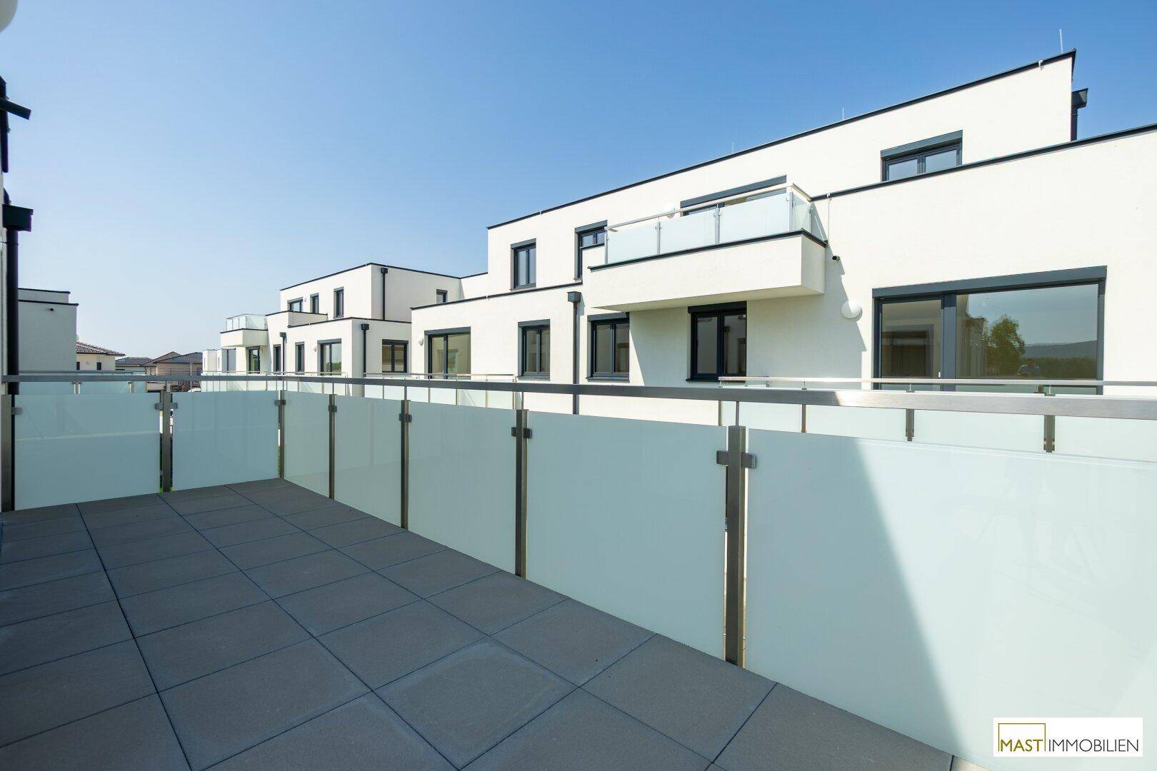 Weitläufige Terrasse mit Blick auf die moderne Architektur der umliegenden Neubauten.