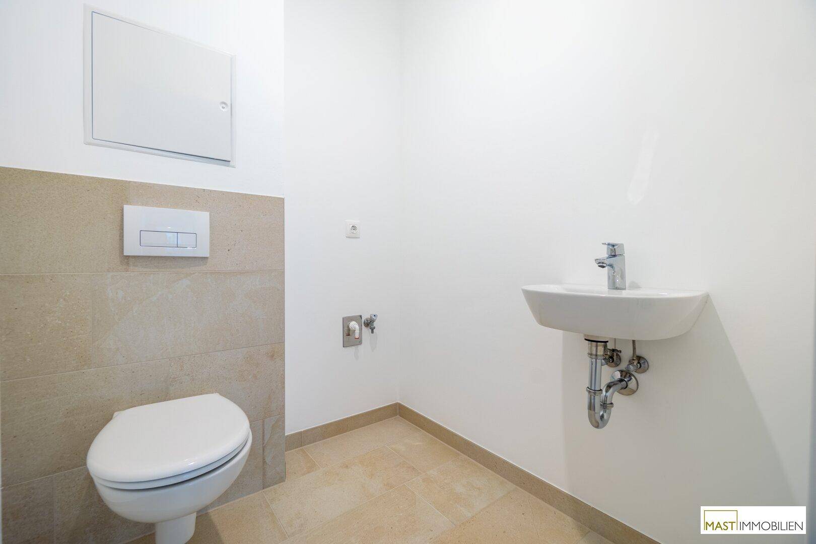 Modernes Gäste-WC mit wandhängender Toilette und kleinem Waschbecken.