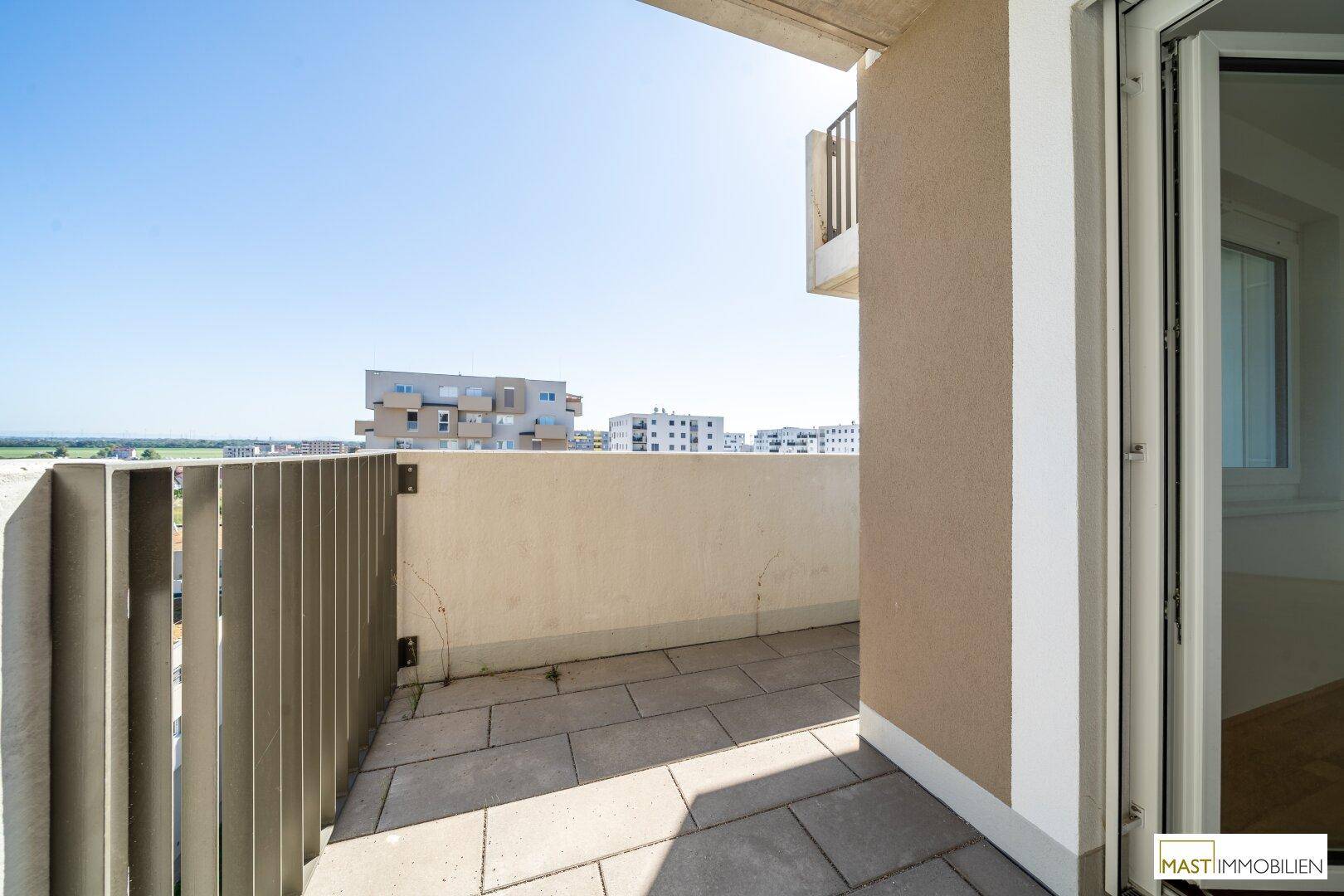 Geräumiger Balkon mit Fliesenboden und moderner Brüstung, bietet einen weiten Blick.