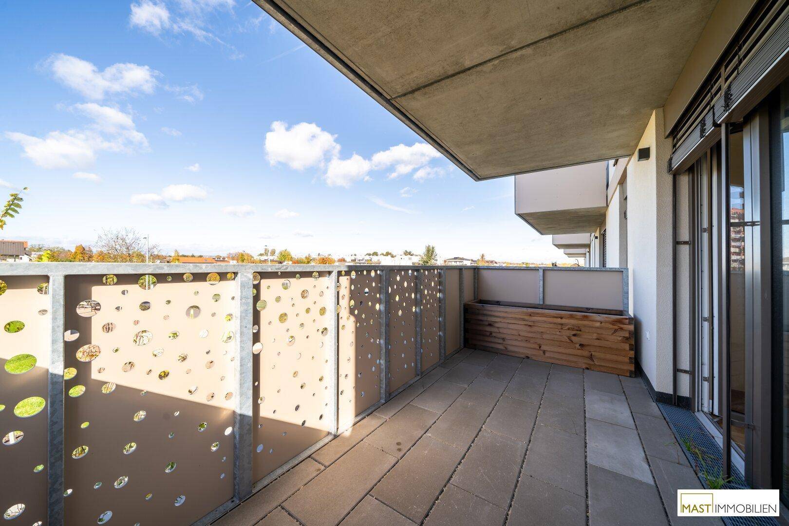 Geräumiger Balkon mit Fliesenboden und dekorativem Geländer, bietet einen weiten Blick über die Umgebung.