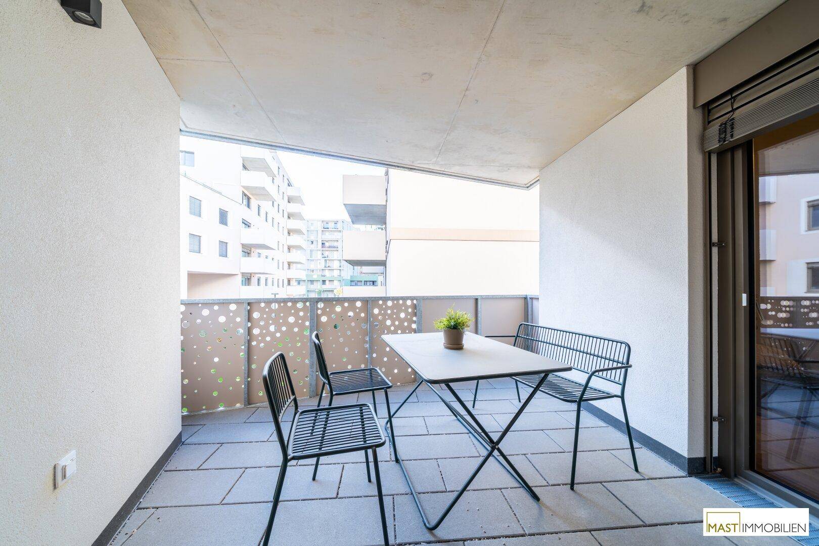 Gemütlicher Balkon mit Sitzgelegenheiten und Blick auf die umliegenden Gebäude.