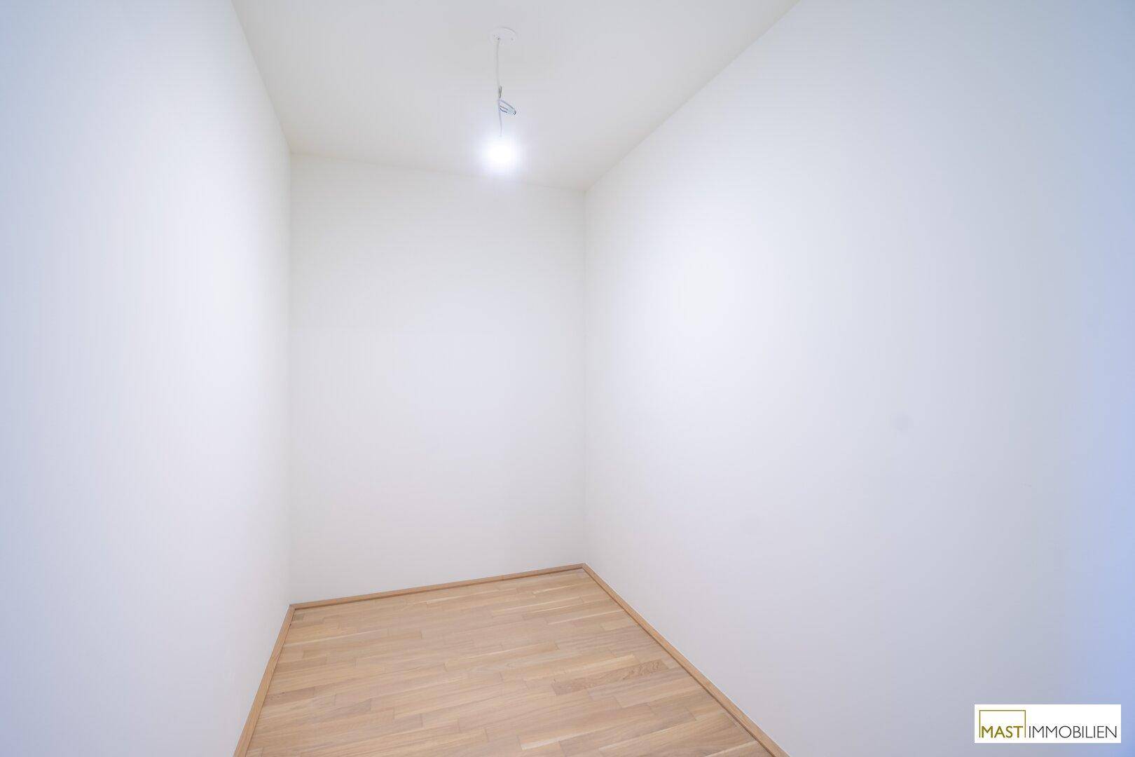 Kleiner, leerer Raum mit Parkettboden und weißen Wänden, ideal als Abstellraum.