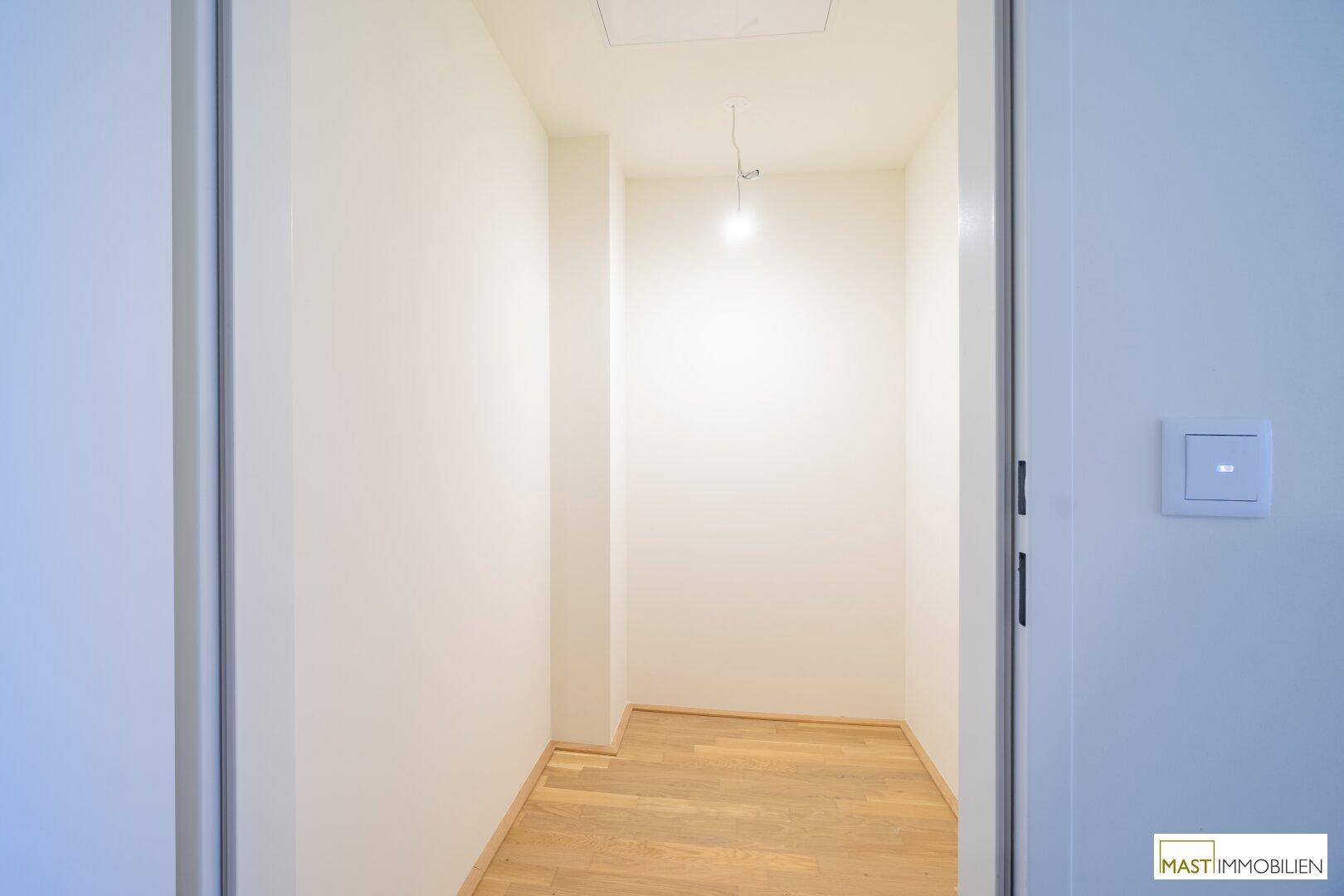 Kleiner, heller Abstellraum mit Holzboden und Zugangsluke zur Decke.