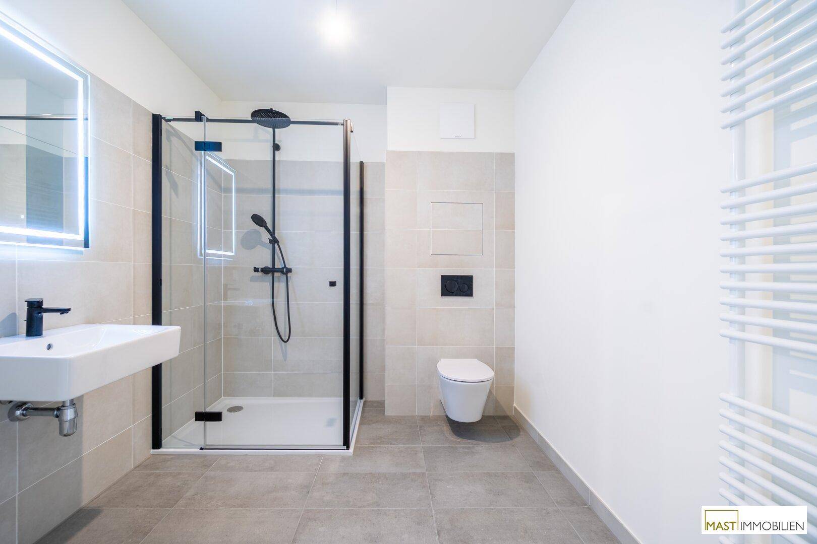 Modernes Badezimmer mit ebenerdiger Dusche, Wand-WC und beheiztem Handtuchhalter.