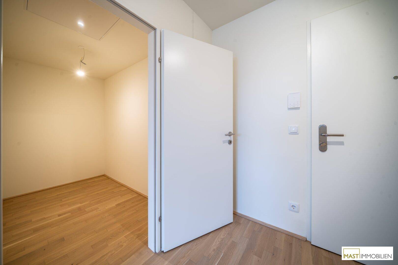 Kleiner, heller Raum mit Parkettboden und weiß gestrichenen Wänden, ideal als Abstellraum oder Büro.