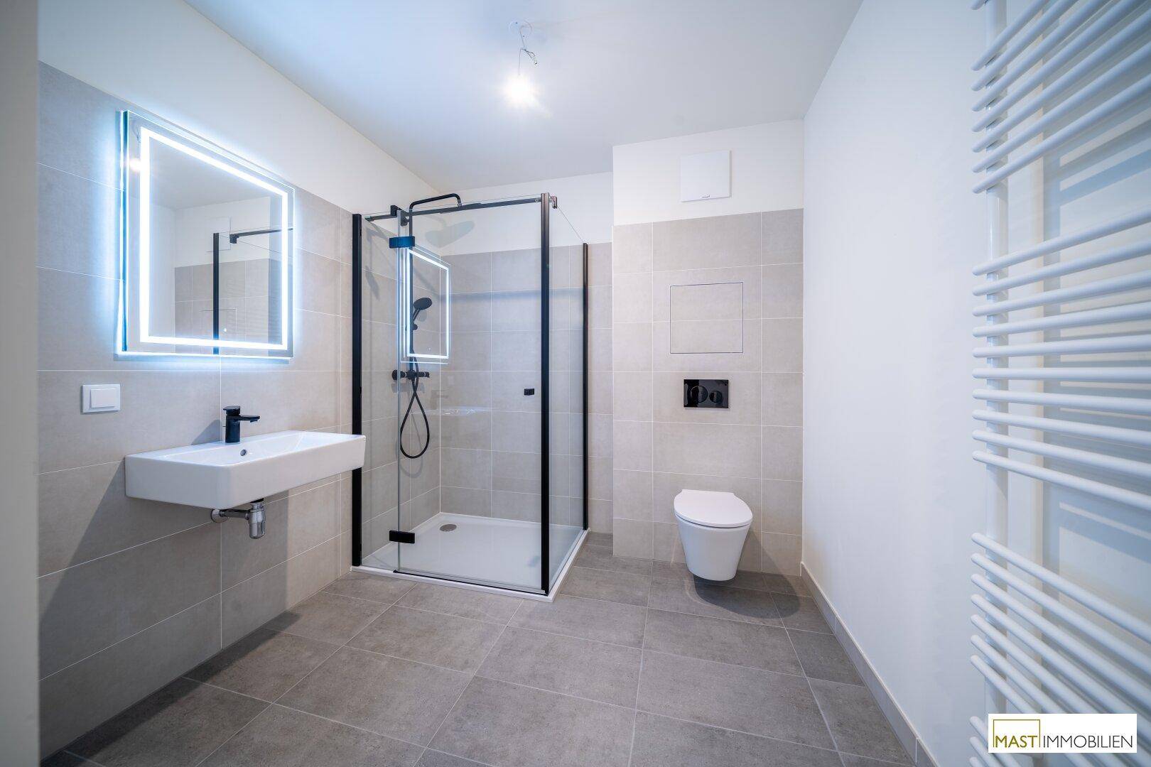 Modernes Badezimmer mit begehbarer Dusche, Wand-WC und eleganten grauen Fliesen.