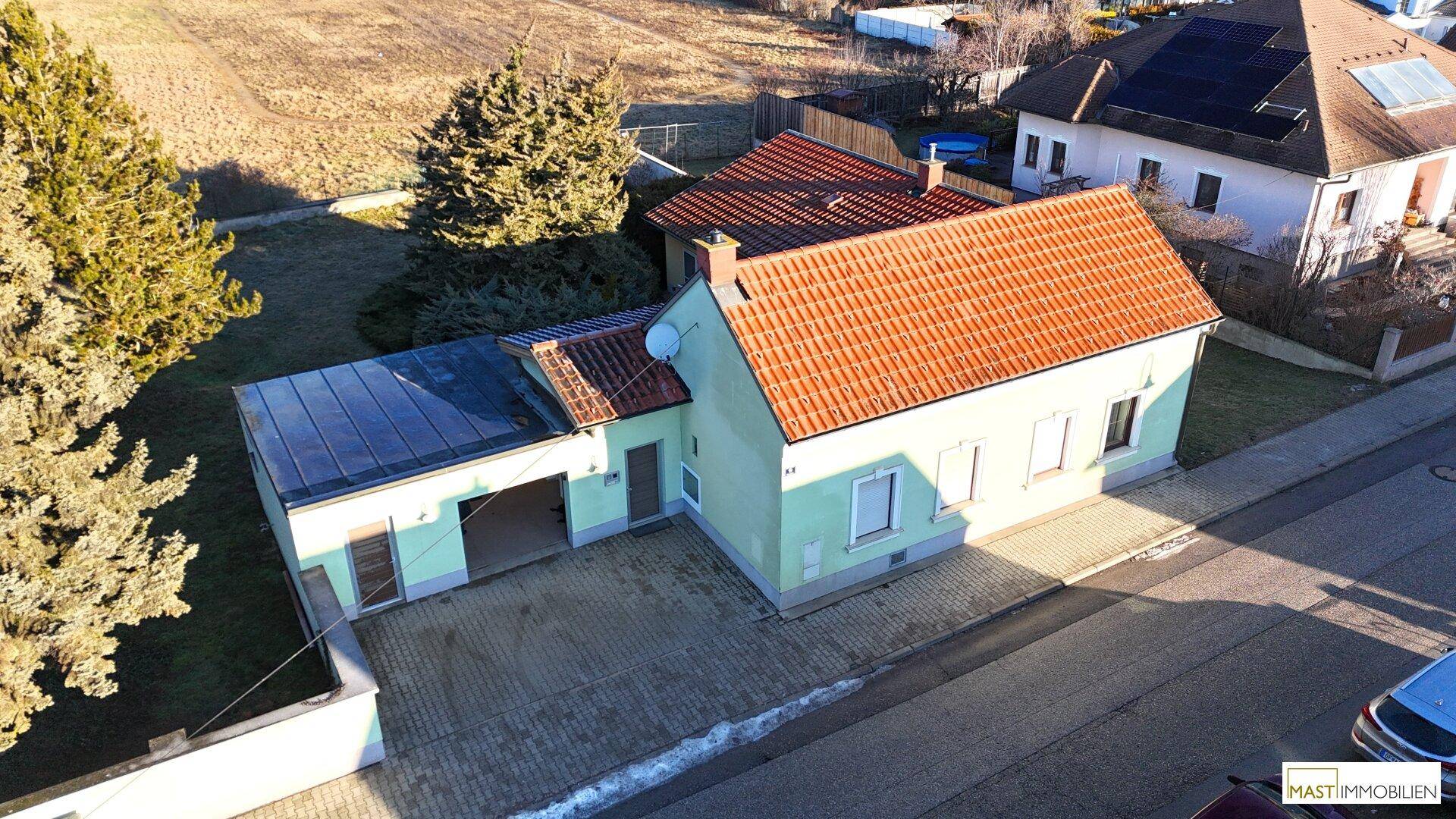 Luftaufnahme des Einfamilienhauses mit Ziegeldach und angrenzender Garage.