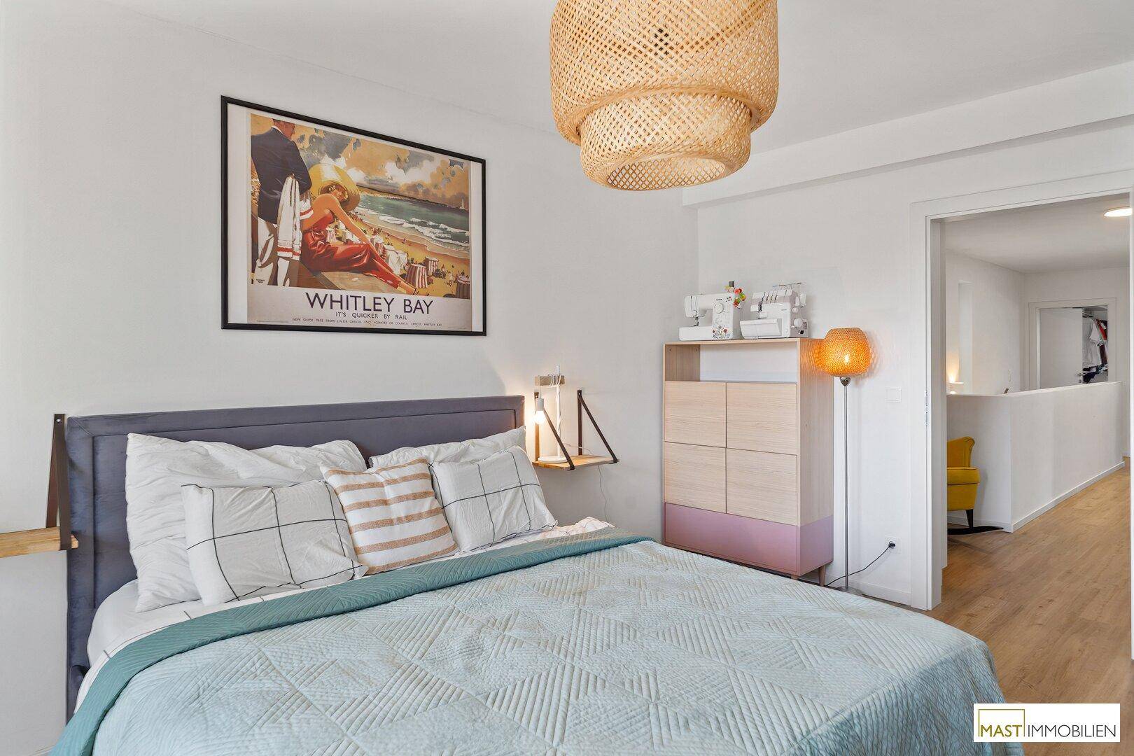 Gemütliches Schlafzimmer mit Doppelbett, Nachttisch und Blick in den Flur.
