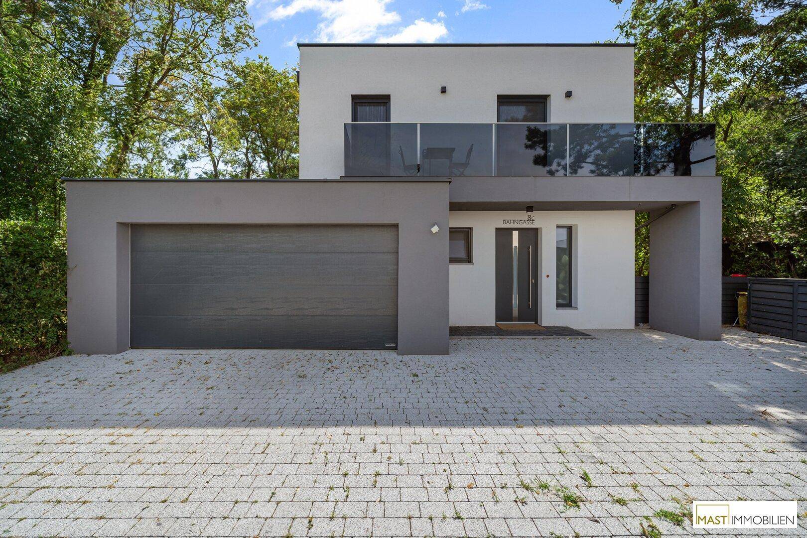 Modernes Einfamilienhaus mit Doppelgarage, Eingangsbereich und Balkon.