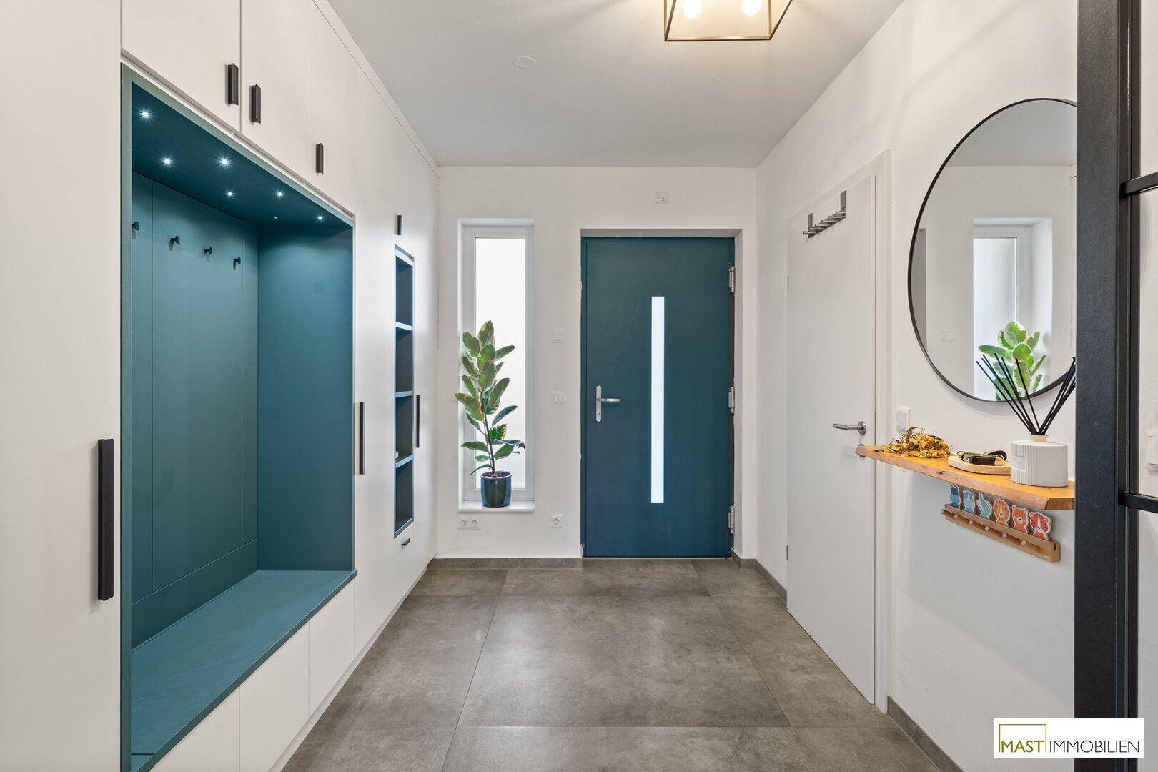Moderner Eingangsbereich mit Einbauschränken, Garderobe und Haustür.