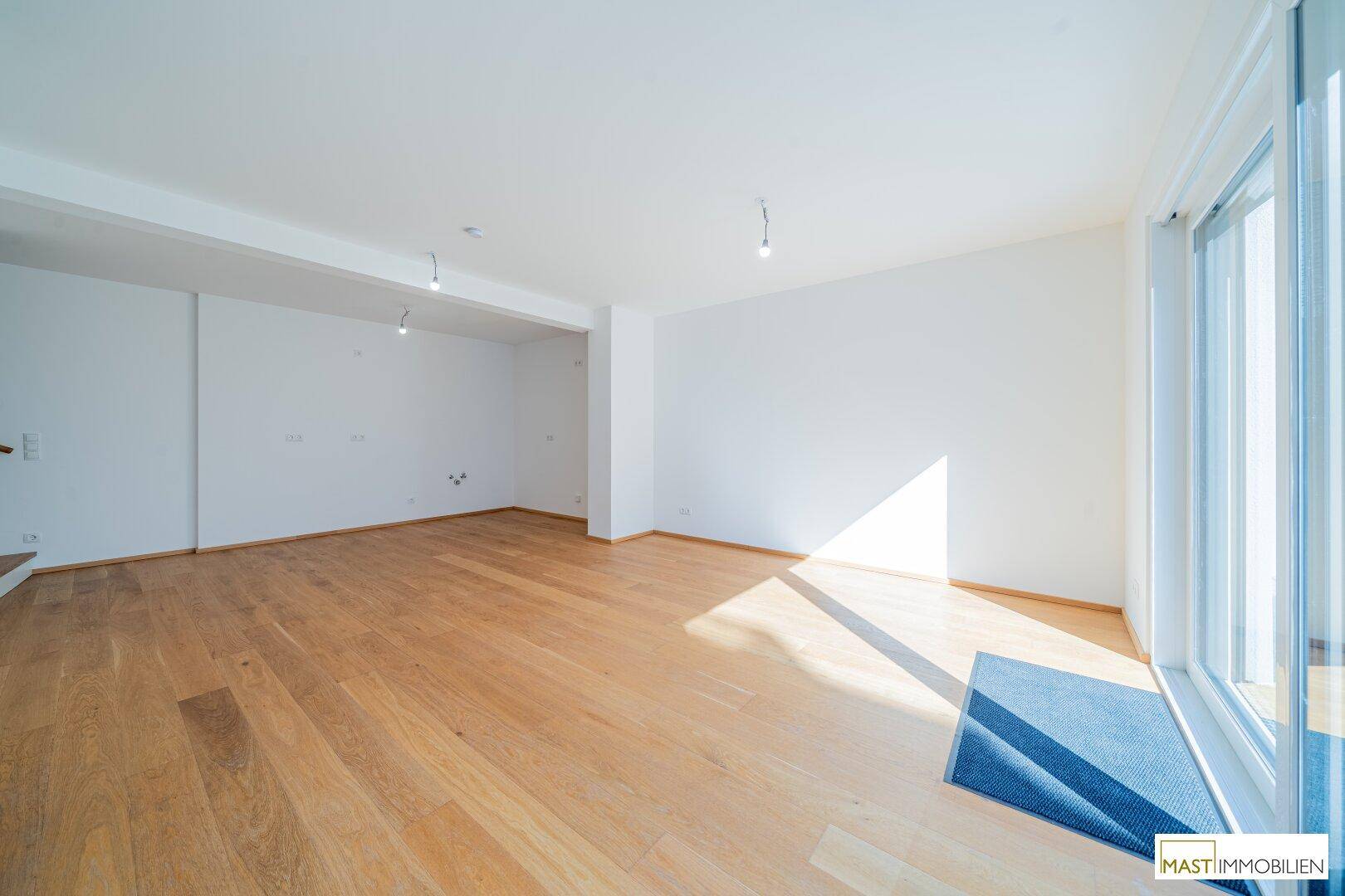 Heller Wohnraum mit großen Fensterfronten und viel Tageslicht, ideal für offenes Wohnen.