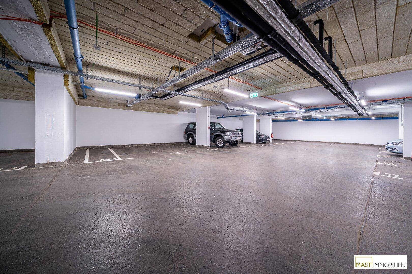 Weitläufige Tiefgarage mit vielen Stellplätzen und guter Beleuchtung.